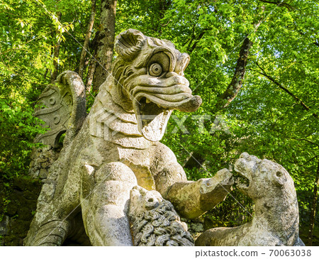 Detail of the winging dragon fighting against three beasts, a huge sculpture at famous Park of the Monsters, also named Sacred Grove, Bomarzo Gardens, province of Viterbo, Lazio, Italy Detail of the winging dragon fighting against three beasts, a huge sculpture at famous Park of the Monsters, also named Sacred Grove, Bomarzo Gardens, province of Viterbo, Lazio, Italy 70063038