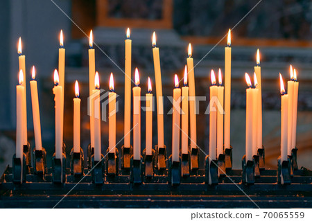 Burning candles in the Catholic Church. Selective focus. Bokeh. Burning candles in the Catholic Church. Selective focus. Bokeh. 70065559
