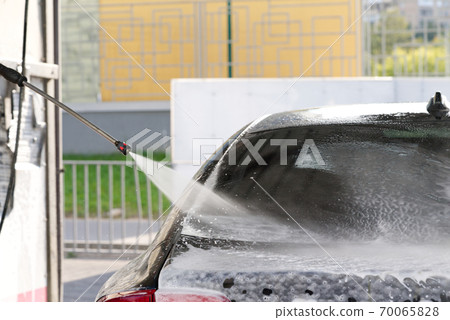 self-washing car service, washes away car shampoo from automobile back window, black car washing, simple work, selective focus self-washing car service, washes away car shampoo from automobile back window, black car washing, simple work, selective focus 70065828