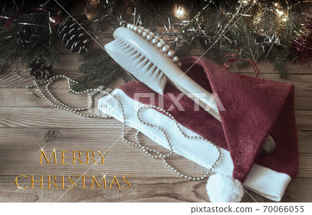 Massage brush and Christmas decorations on wooden background. 70066055