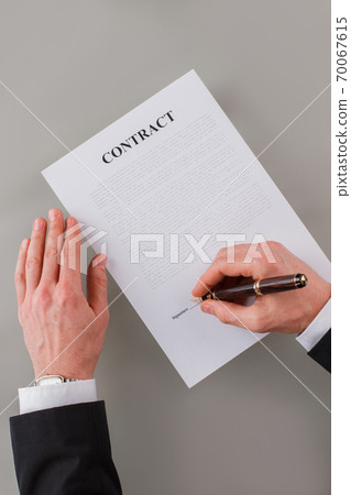 Top view of male executive signing a business contract. Top view of male executive signing a business contract. 70067615