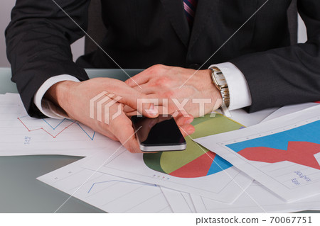 Businessman using cell phone with blank screen display. Businessman using cell phone with blank screen display. 70067751
