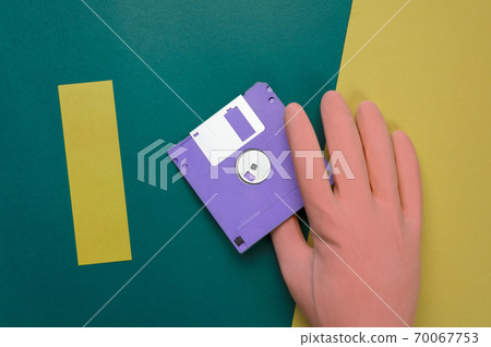 hand in pastel rubber glove with purple diskette on retro yellow colorful paper background hand in pastel rubber glove with purple diskette on retro yellow colorful paper background 70067753