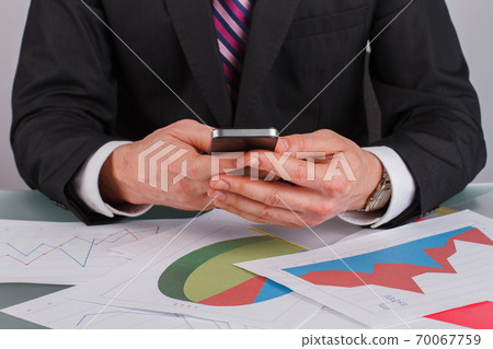 Close up businessman analyzing financial graphs and charts. 70067759