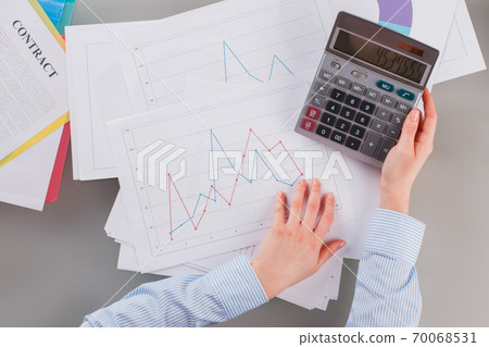 Female accountant using calculator in office. 70068531