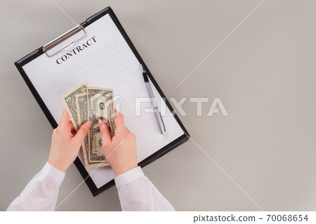 Business woman counting money on table with contract. 70068654