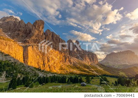 A stunning sunset view of the Dolomites Alps painted gold from the setting sun 70069441