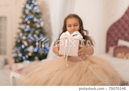 Happy childhood, magical Christmas tale. Little princess with Santa's present for Christmas Happy childhood, magical Christmas tale. Little princess with Santa's present for Christmas 70070146