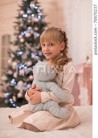 Santa brought a teddy bear to the little girl for Christmas Santa brought a teddy bear to the little girl for Christmas 70070237