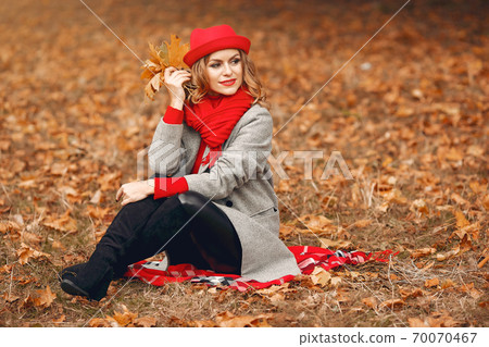 Beautiful woman sitting in a autumn park 70070467
