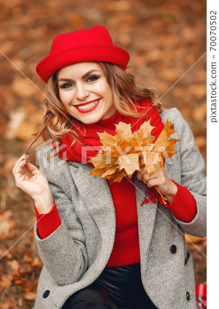 Beautiful woman sitting in a autumn park Beautiful woman sitting in a autumn park 70070502