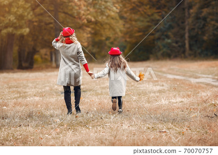 Cute and stylish family in a autumn park Cute and stylish family in a autumn park 70070757