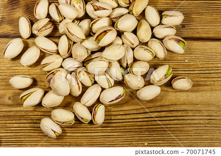 Pistachio nuts on a wooden table. Top view 70071745