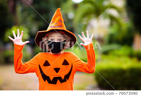 Kids trick or treat. Halloween in face mask. 70073090