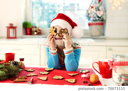 Kids bake Christmas cookies. Child cook for Xmas. Kids bake Christmas cookies. Child cook for Xmas. 70073133