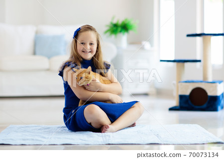 Child playing with cat at home. Kids and pets. Child playing with cat at home. Kids and pets. 70073134