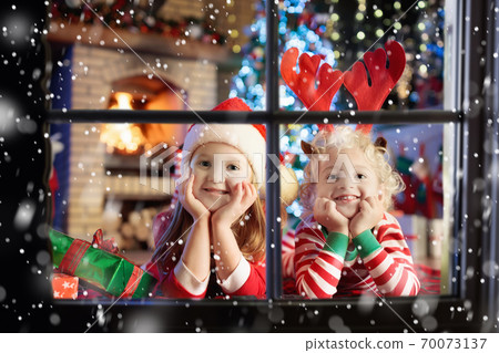 Child at Christmas tree. Kids at fireplace on Xmas 70073137