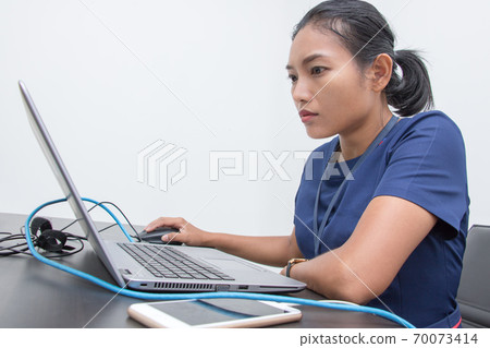 A young busy woman is looking at a laptop. Business woman working in office with computer 70073414