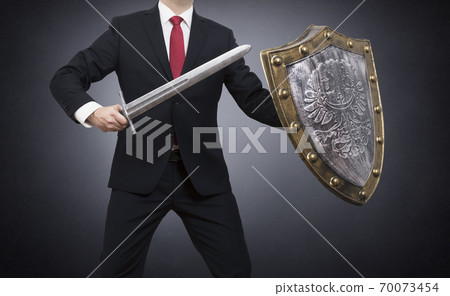Businessman with sword and shield on dark background with clipping path. Business protection concept. 70073454