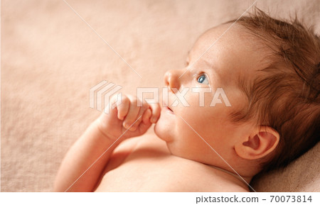 Portrait of a baby boy on a beige background. 70073814