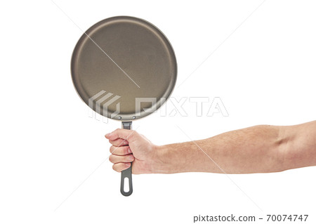 Hand holding a black frying pan isolated on white background Hand holding a black frying pan isolated on white background 70074747