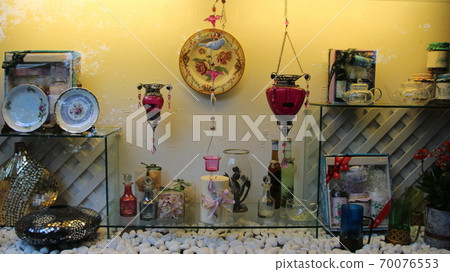 Display stand decorated with glass bottles and dishes 70076553