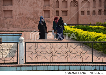 A Muslim woman walking on the sidewalk of the unfinished castle ruins of Lalbagh Fort Gardens in Dhaka, Bangladesh A Muslim woman walking on the sidewalk of the unfinished castle ruins of Lalbagh Fort Gardens in Dhaka, Bangladesh 70076632