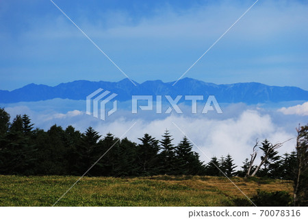 Northern Yatsugatake in early autumn, overlooking the Ushiro-Tateyama mountain range in the Northern Alps from Futagoyama Northern Yatsugatake in early autumn, overlooking the Ushiro-Tateyama mountain range in the Northern Alps from Futagoyama 70078316