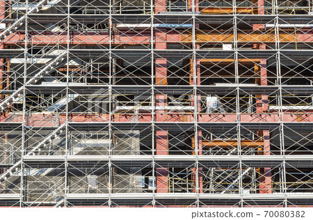Construction site of a building surrounded by scaffolding 70080382