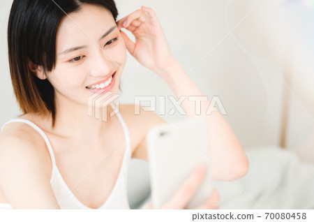 Young beautiful oriental young women at home daily 70080458