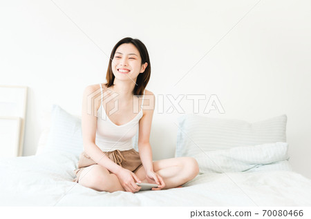 Young beautiful oriental young women at home daily 70080466