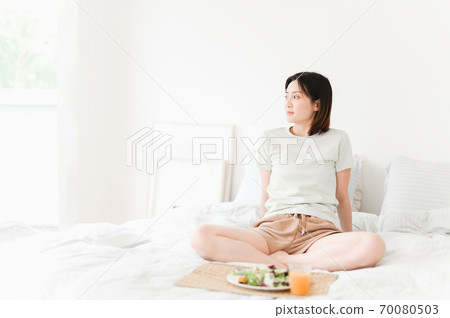 Young beautiful oriental young women at home daily 70080503