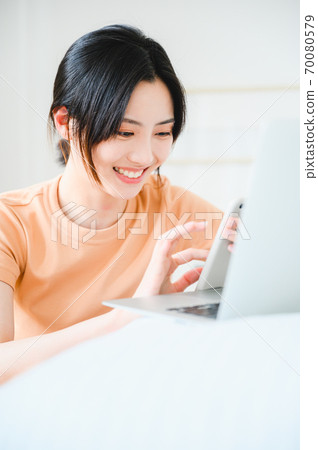 Young beautiful oriental young women at home daily 70080579