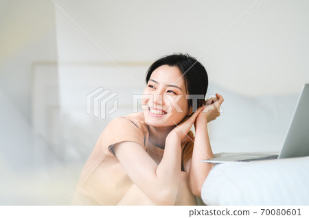 Young beautiful oriental young women at home daily 70080601