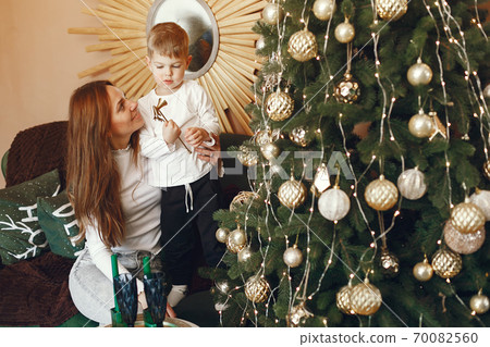 Mother with cute son near christmas tree Mother with cute son near christmas tree 70082560