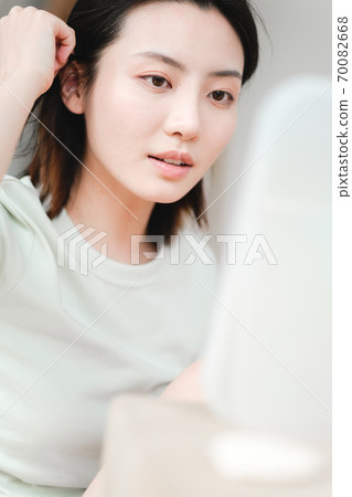 Young beautiful oriental young women at home daily 70082668