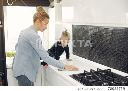 Mom and daughter clean up in the kitchen Mom and daughter clean up in the kitchen 70082759