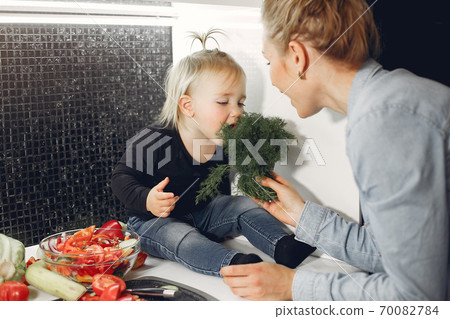 Beautiful family prepare food in a kitchen Beautiful family prepare food in a kitchen 70082784