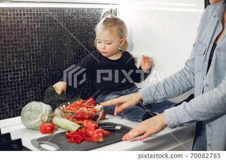 Beautiful family prepare food in a kitchen Beautiful family prepare food in a kitchen 70082785