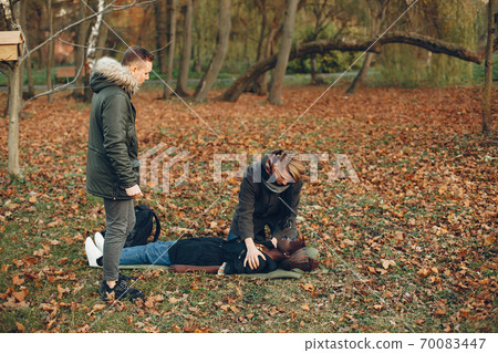 Two boys in a autumn park help a african girl Two boys in a autumn park help a african girl 70083447