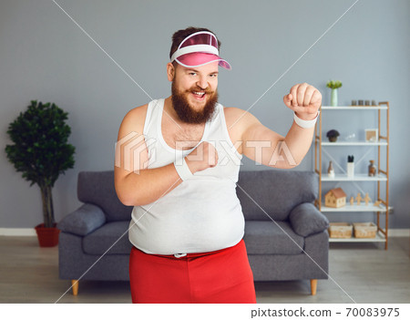 Funny fat boxer in sportswear is boxing in the room. Funny fat boxer in sportswear is boxing in the room. 70083975