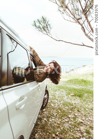 young pretty woman stick out from car window sea beach on background young pretty woman stick out from car window sea beach on background 70083976