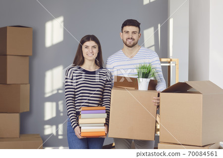 Young couple family with boxes to move in a new house room. Young couple family with boxes to move in a new house room. 70084561