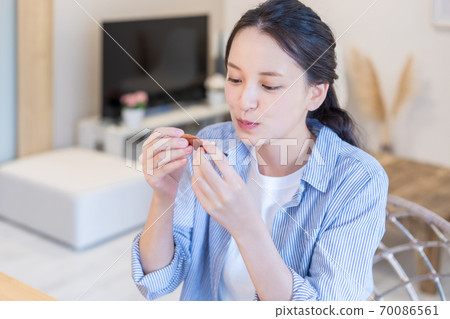 Young woman eating figs 70086561