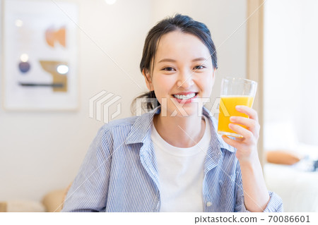 年輕女子在家裡喝橙汁 70086601