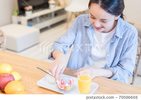 Young woman eating figs 70086608
