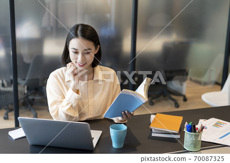 一方面用參考書製定計劃的商務人士 70087325