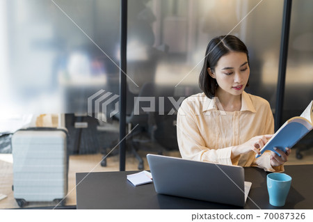 一方面用參考書製定計劃的商務人士 70087326