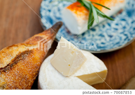 French cheese and fresh baguette on a wood cutter French cheese and fresh baguette on a wood cutter 70087853