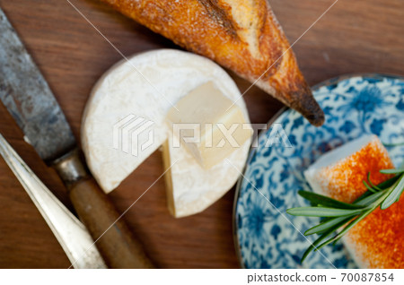 French cheese and fresh baguette on a wood cutter French cheese and fresh baguette on a wood cutter 70087854